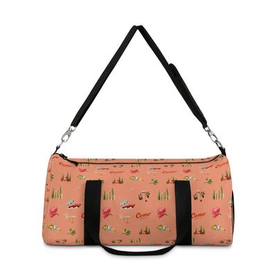 Peach duffel bag with black strap on a white background