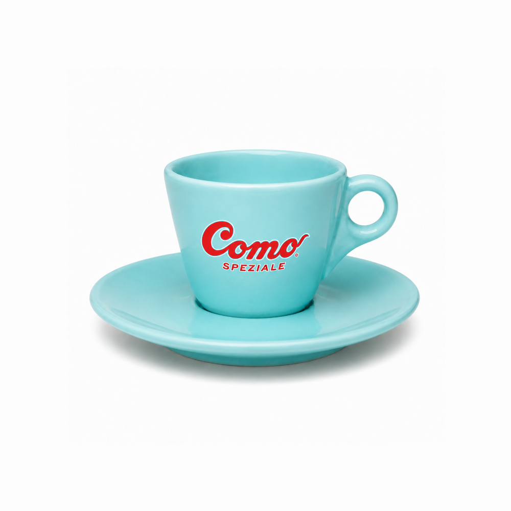 A light blue ceramic espresso cup with a matching saucer, featuring the red 'Como Speziale' logo on the side, set against a plain white background.