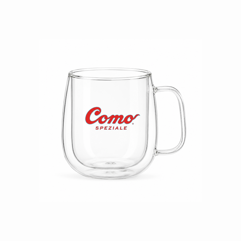 A clear double-walled glass mug with a handle, featuring the red 'Como Speziale' logo printed on the front, set against a plain white background.